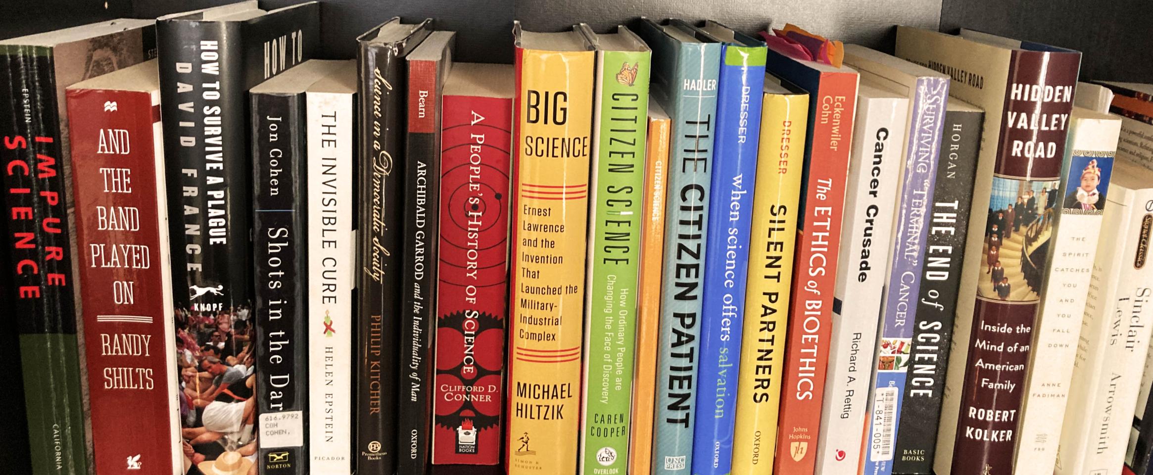 Photo of a bookshelf containing some of the books Amy Marcus read to understand the history of patient-led activism, the ethics of collaboration between patients and scientists, and the history of science in the modern era. Photo by Amy Marcus