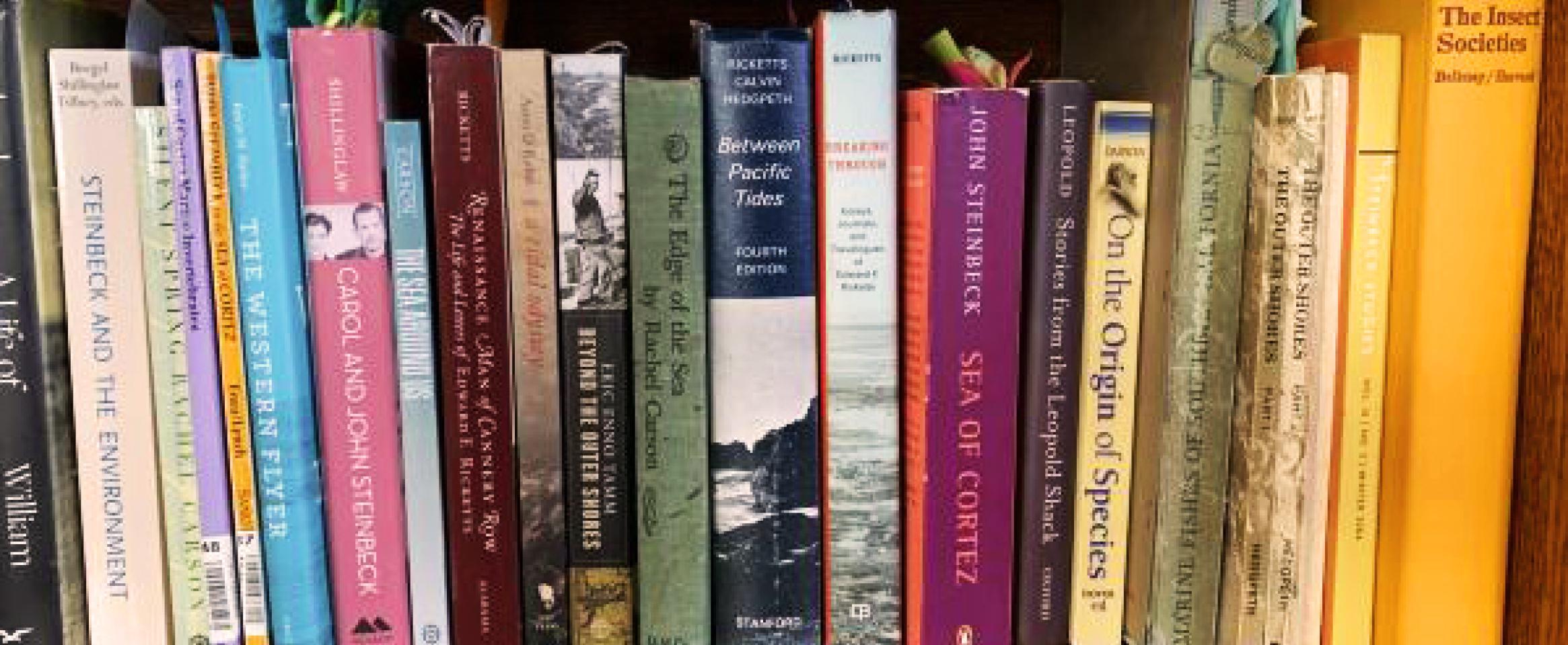 Horizontal photo of a bookshelf of Liz Lee Heinecke, featuring titles on conservation, ecology, and evolution. Photo by Liz Lee Heinecke