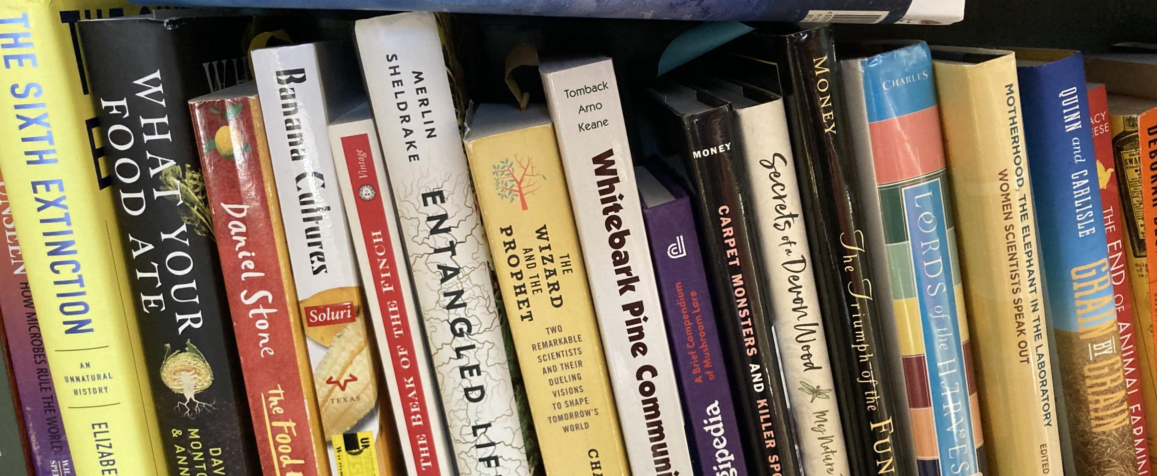  Rectangular photo of Emily Monosson’s office bookshelf showing titles on fungi and natural history. Photo credit Emily Monosson.