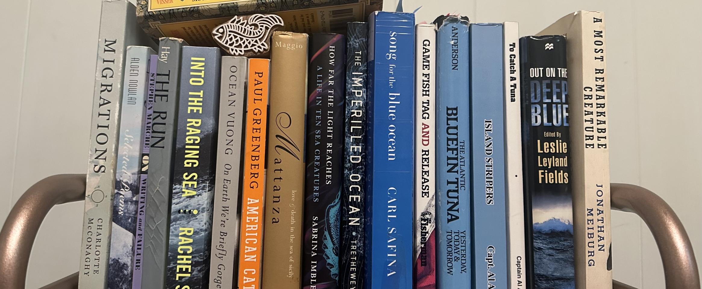 Rectangular photo of Karen Pinchin’s office bookshelf showing books on ocean life and fishing in general and bluefin tuna in particular. Photo credit Karen Pinchin.