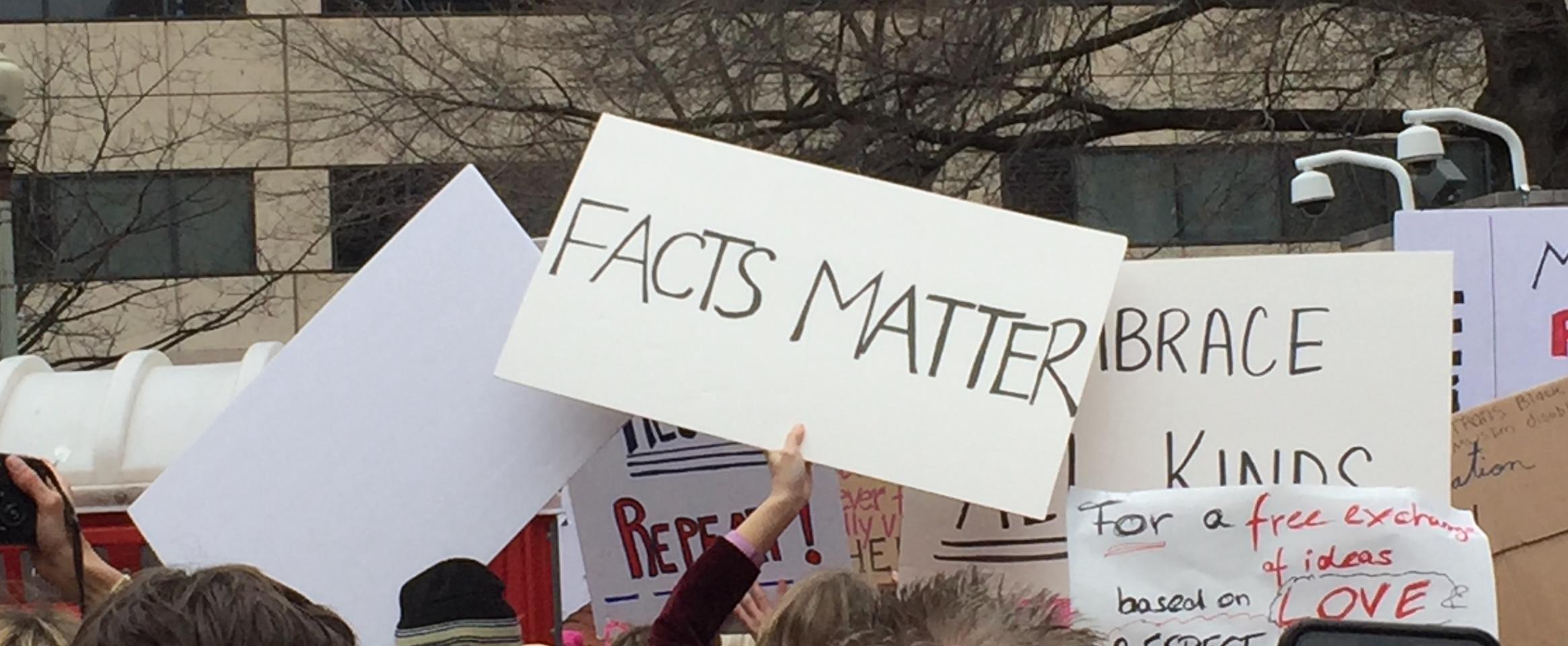 Rectangular photo of Women’s March in Washington DC, January 21, 2017, with signs reading “Facts Matter.” Photo credit Brooke Borel.