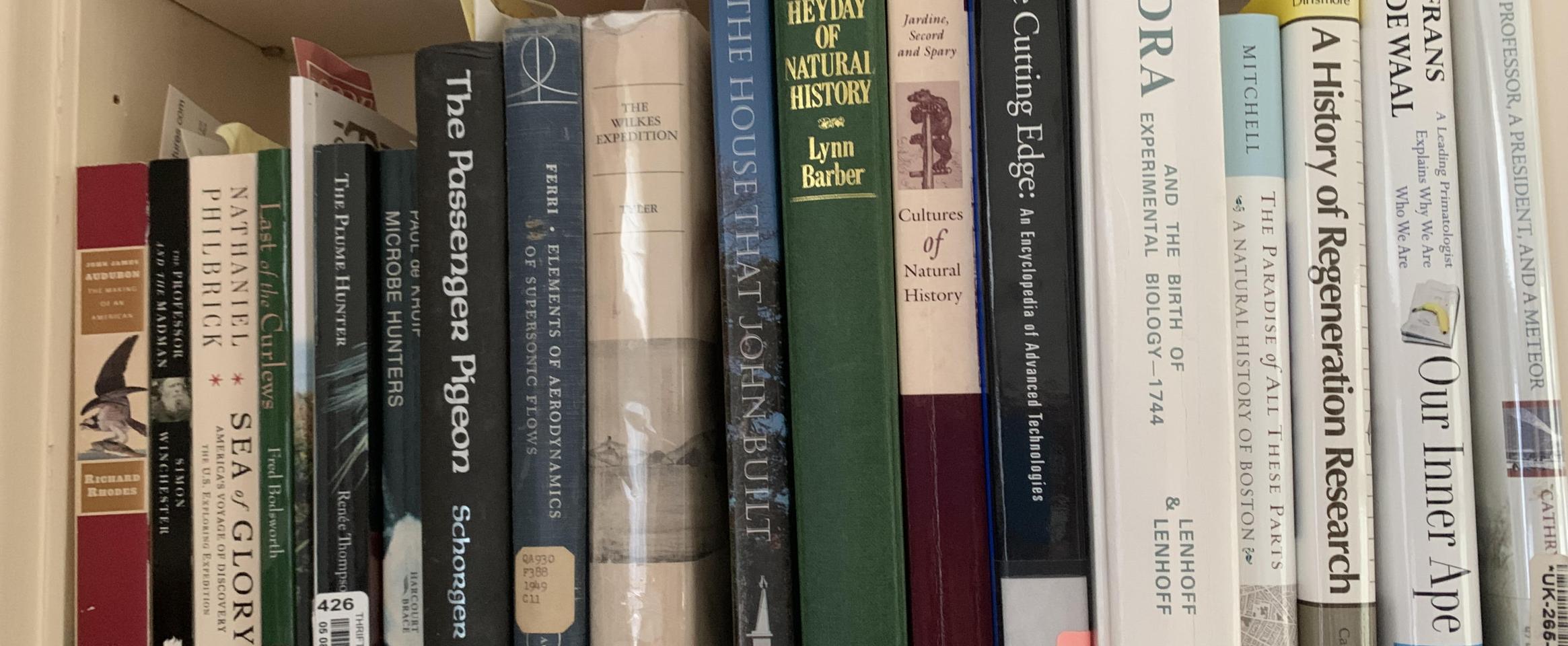 Rectangular photo of Ann Parson’s office book shelf showing works on explorers’ travels, natural history, and the development of technologies. Photo credit: Ann Parson.