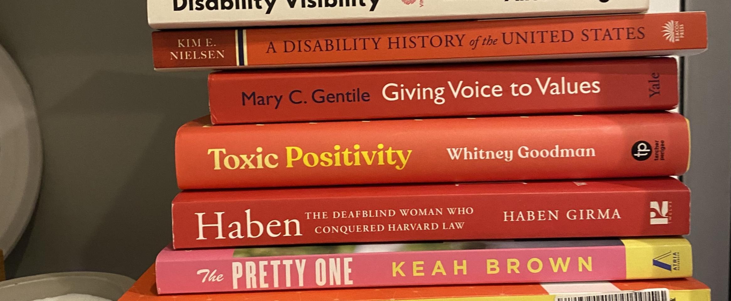 Rectangular photo of Gabi Serrato Marks’ office bookshelf showing works on disability history and visibility, as well as science writing and science communication. Photo credit: Gabi Serrato Marks.