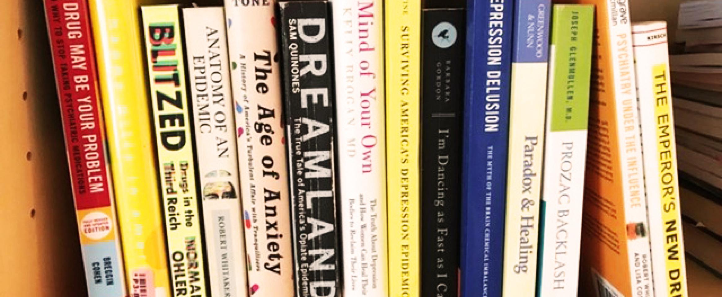 Rectangular photo of Ann Bracken’s office bookshelf showing titles on depression, anxiety, the opioid crisis, and psychoactive medications. Photo credit Ann Bracken.