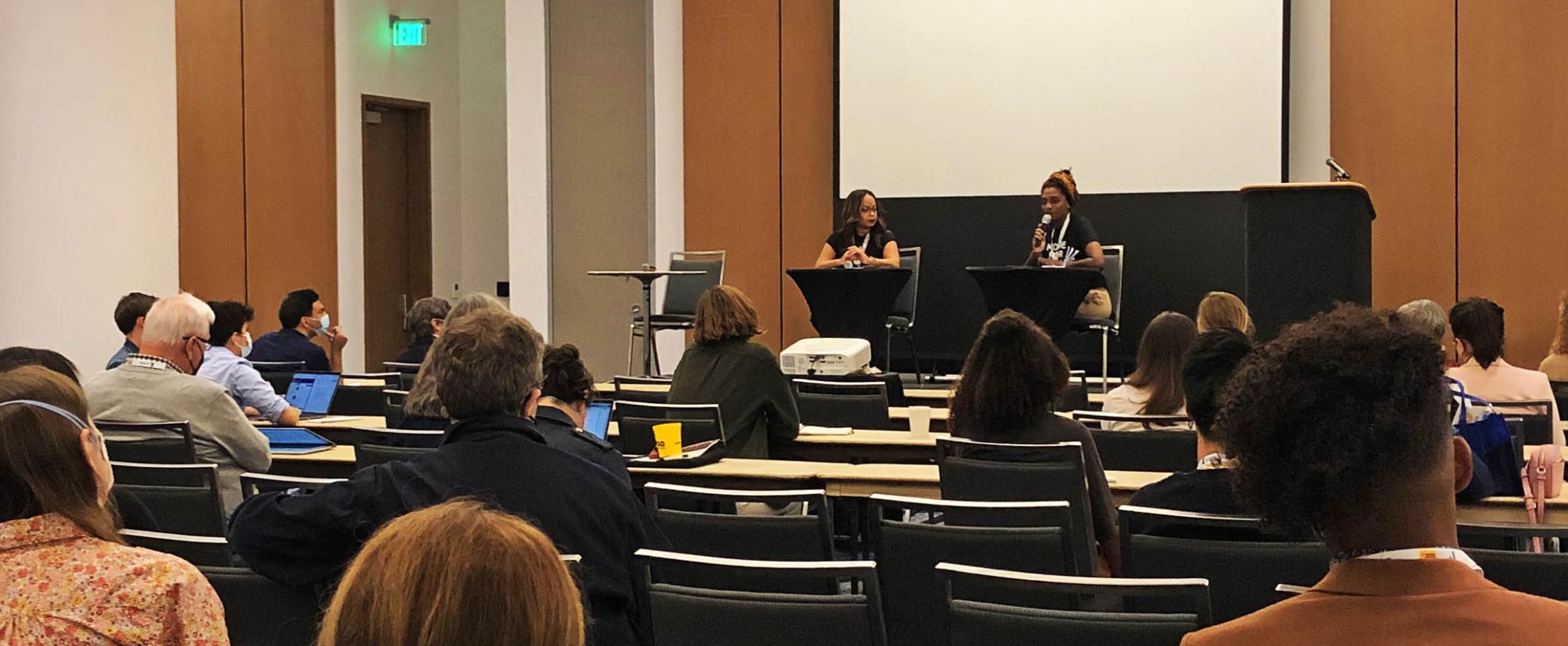 Horizontal photo of Wendi C. Thomas and Ayanna Hampton in conversation on stage at the Science Writers 2022 annual meeting in Memphis, with seated attendees in the foreground