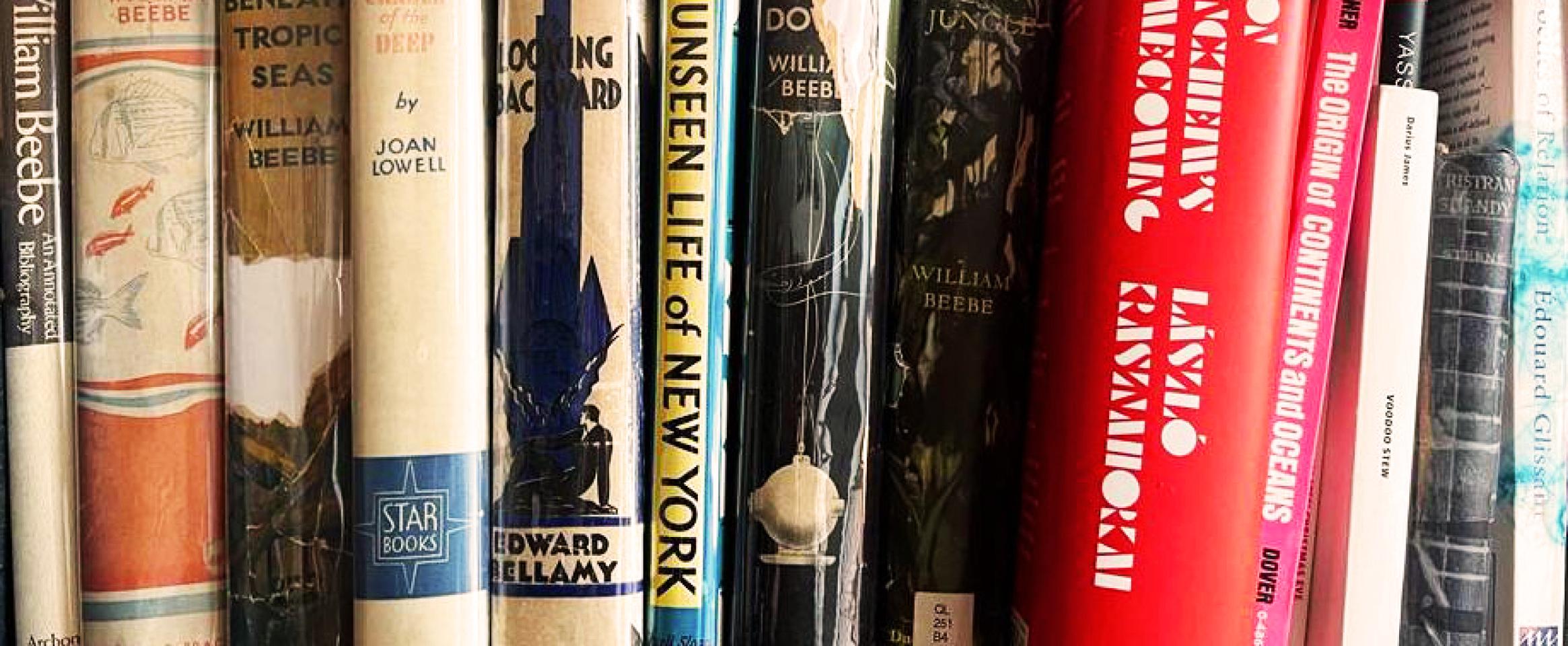Horizontal photo of a bookshelf of Brad Fox, featuring many old titles by William Beebe