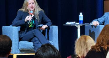 Photo of panelist Nadia Drake seated on stage speaking at Science Writers 2023. Photo by Paul Adepoju
