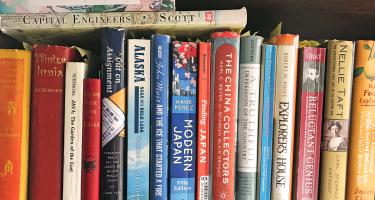Horizontal photo of a shelf of books used by Diana P. Parsell for research on forthcoming book, "Eliza Scidmore: The Trailblazing Woman Behind Washington's Cherry Trees" Photo by Diana Parsell