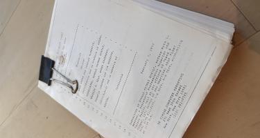 Rectangular photo of Brendan Borrell’s desktop, showing some of the thousands of pages of court documents, including some providing days of Scholz’s own testimony, from the decade-long battle between Tom Scholz and his record label when he refused to hand over his third album until it met his exacting standards. Photo credit: Brendan Borrell.