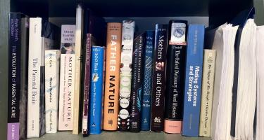 Rectangular photo of Elizabeth Preston’s office bookshelf showing works on topics that include the evolution of parental care, Mother Nature, Father Nature, biology as ideology, social instincts, mating systems, and Charles Darwin’s The Voyage of the Beagle. Photo credit: Elizabeth Preston.