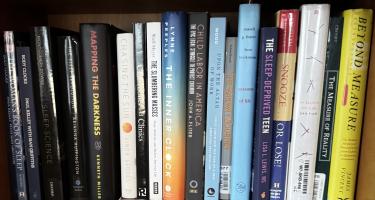 Rectangular photo of Terra Ziporyn’s office bookshelf showing works on the history and nature of sleep and circadian science, including three books by other NASW authors: Kenneth Miller, Lisa Lewis, and Lynne Peeples. Photo credit: Terra Ziporyn.