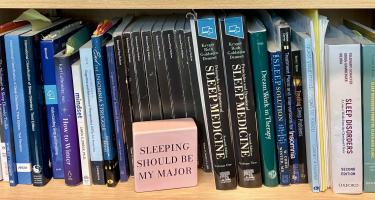 Rectangular photo of Brad Wolgast’s office bookshelf showing books on sleep for sleep specialists and the public. Photo credit: Brad Wolgast