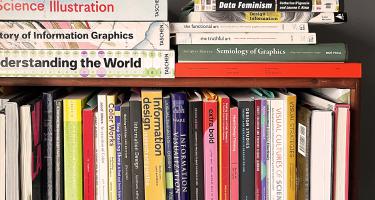 Horizontal photo of a bookshelf with the tops of books visible, along with books stacked atop. The titles all relate to scientific illustration.