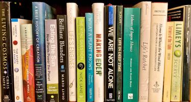 Rectangular photo of a close up view of books on Dan Levitt's bookshelv. Image credit Dan Levitt