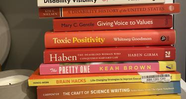 Rectangular photo of Gabi Serrato Marks’ office bookshelf showing works on disability history and visibility, as well as science writing and science communication. Photo credit: Gabi Serrato Marks.