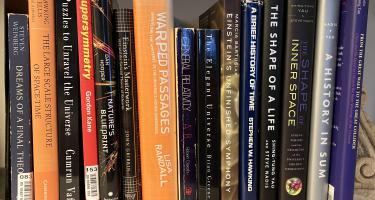 Rectangular photo of Steve Nadis’ office bookshelf showing several works on Einstein, general relativity, and space-time, along with Nadis’ and his coauthor’s previous books on these topics. Photo credit: Steve Nadis.