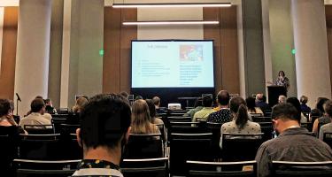 Photo of a conference room with screen in distance reading the Debunk and a photo of American football star Aaron Rodgers, taken at Science Writers 2022. Image by Ben Young Landis