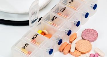 Weekly pill container with a variety of colorfull pills.
