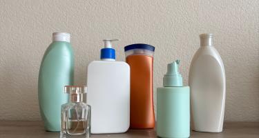 Unlabeled bottles on a shelf, representing personal care products.