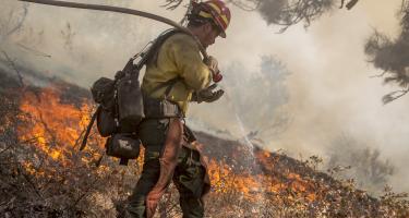 An Idaho firefighter douses flames in the Boise National Forest