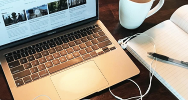 Photo of a keyboard and notepad with pen