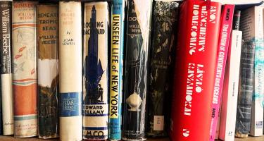 Horizontal photo of a bookshelf of Brad Fox, featuring many old titles by William Beebe