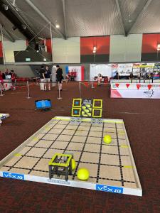 Photo of the rectangular setup for 2024 VEX robotics theme “Rapid Relay" with a walled platform on a gymnasium floor.