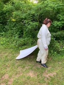 A Northern Kentucky University undergraduate student drags for ticks while wearing a protective suit.
