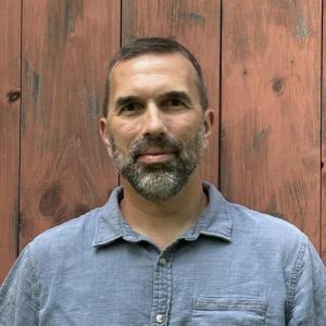 Portrait photo of Chris Berdik in an outdoor setting.
