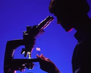 Woman at microscope in silhouette