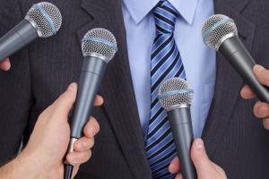 Interviewee with microphones image via Shutterstock