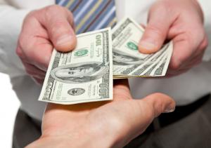 Cash exchanging hands image via Shutterstock