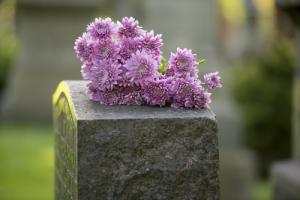 Flowers on headstone image via Shutterstock
