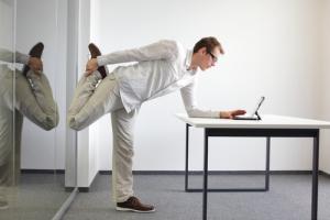 Man stretching at desk image via Shutterstock