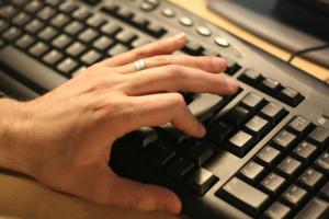Hand on keyboard image via Shutterstock