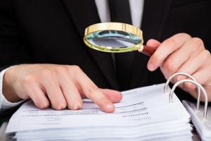 Examine a page with magnifying glass image via Shutterstock