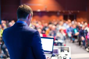 Conference speaker image via Shutterstock