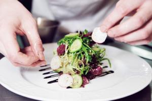 Chef arranging salad, image via Shutterstock