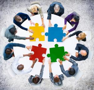 Puzzle-solving meeting image via Shutterstock