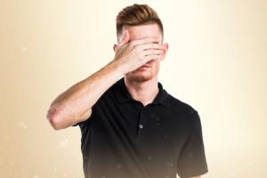 Man covering eyes, image via Shutterstock