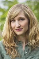 Vertical headshot photo of Ashley Braun, with shoulder length hair and standing outdoors