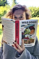 Portrait photo of Emma Marris peering from behind her book Wild Souls